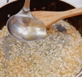 Когда вино испарится, добавляйте понемногу в рис горячий бульон (примерно 1 средний половник). Все время перемешивайте рис и держите сковороду на слабом огне. Готовить рис нужно до состония альденте (на зубок). Т.е. рис не должен быть очень мягким, слегка твердым.	