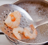Очистите креветки и отварите их в кипящей подсоленной воде 1-2 минуты (в зависимости от из размера). Не переварите, а то они станут резиновыми!	