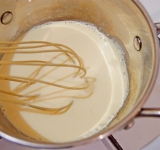 Залейте сливки в кастрюлю, доведите до кипения и сразу снимите в плиты. В отдельной емкости взбейте яичный желток, затем, доливая сливки, продолжайте взбивать.	