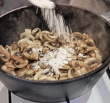 Добавьте муку, перемешайте и готовьте 1 минуту. Уберите грибы со сковороды.	