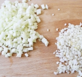 Лук очистите и мелко нарежьте, яблоки очистите и порежьте на кубики по 1 см.  
Лук обжарьте на сковороде на среднем огне на жире от бекона в течении 5 минут.	