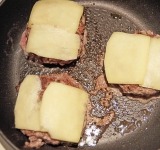 Когда будете переворачивать котлеты на другую стороны, положите сверху сыр. Таким образом он слегка расплавится.  
На нижнюю часть булочки выложите мясо с сыром, сверху положите любимые добавки (маринованные огурчики, помидоры, кетчуп, горчицу и тд) и накройте верхней булочкой.  
Приятного аппетита!	