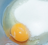 Взбейте яйцо с сахаром и ванильным сахаром до плотной кремообразной консистенции.	