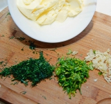 Измельчите зелень. Чеснок очистите и измельчите.	