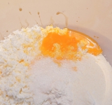 Добавьте к творогу остальные ингредиенты (кроме масла) и хорошо перемешайте. Можете добавить к сырникам и какую-нибудь начинку (изюм, сушеная вишня и пр).