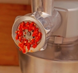 Пропустите чеснок, кориандр и перец через мясорубку несколько раз.