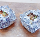 Заверните каждое яблоко в фольгу, оставьте сверху небольшое отверстие. Положите яблоки в фольге на противень или в жаропрочное блюдо и поставьте в духовку примерно на 35 минут.  
Перед подачей полейте медом (если любите).  
Приятного аппетита!	