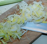 Лук-порей разрежьте пополам (вдоль) и промойте от песка. Разрежьте на полукольца.