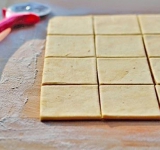 Взбейте сливочный сыр с растопленным сливочным маслом и сахаром.  
Просейте муку с солью и перемешайте. Желательно поставить в холодильник на 30 минут. 
Раскатайте тесто в пласт толщиной около 3 мм, разрежьте на квадраты 6 на 6 см.	