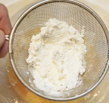 Творог пропустите через сито или разомните вилкой и добавьте к яичной массе.	