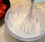 Взбейте сливки с сахарной пудрой до состояния взбитых сливок. Порежьте клубнику на кусочки и добавьте к сливкам и перемешайте.  
На нижний коржик положите взбитые сливки, сверху накройте вторым кусочком. Сверху посыпьте сахарной пудрой.  
При желании можно сделать еще один «этаж» пирожному: сверху еще положить взбитых сливок, а затем третий коржик.  
Приятного аппетита!	