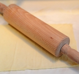 Тесто раскатайте в пласт на бумаге для выпекания. Обрежьте края, чтобы получился прямоугольник. Выложите тесто вместе с бумагой для выпекания на противень (на бумаге, чтобы тесто сохранило форму прямоугольника). На тесто выложите еще один лист бумаги запекания, а сверху поставьте либо второй противень, либо разделочную доску. Сверху поставьте груз. Всю эту “конструкцию” поставьте в духовку на 20 минут (до готовности теста). Благодаря этому тесто не поднимется и останется плоским.	