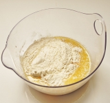 В молоко с дрожжами добавьте яйца, растопленное сливочное масло, лимонную цедру, просеянную муку с солью.	