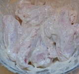 Куриные крылышки промойте и поместите в маринад. Накройте пищевой пленкой и оставьте на 2-4 часа.	