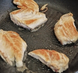 На сковороду положите курицу и на жире от бекона пожарьте до готовности (при необходимости добавьте сливочного масла). Посолите, поперчите курицу и нарежьте на квадратики толщиной около 2 см.  
Гренки положите маслом вверх, сверху положите небольшие кусочки зеленого салата (порвите руками), сверху бекон и курицуразрежьте на небольшие кусочки. Лист салата порвите на небольшие кусочки и положите на гренки. Сверху положите кусочек бекона.  
Возьмите шпажку, насадите на нее оливку, затем наши «горки» (через бекон, салат и гренку) и в самых низ кусочек курочки.  
Канапе готовы! Приятного аппетита!	