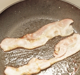 Бекон обжарьте на сковороде на среднем огне без масла до хрустящей корочки с двух сторон (примерно 4 минуты). Затем обсушите на бумажных полотенцах от лишнего жира.	