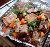 В это время порежьте на крупные кусочки сельдерей, морковь, зеленую часть лука порей. Лук репчатый (не очищая) порежьте на 4 части. Вытащите противень с мясом и добавьте туда порезанные овощи. Поставьте в духовку еще на 20 минут.