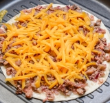 За это время поставьте разогреваться сковороду гриль, затем положите в сковороду одну лепешку, на нее накладывайте грибную начинку и сверху посыпьте сыром, накройте второй лепешкой и готовьте еще немного. Затем аккуратно переверните лепешку на другую сторону и готовьте еще около минуты.
Подавайте на стол. Можно добавить сверху еще соус.
Приятного аппетита!