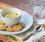 Возьмите мисочку и приготовьте в ней кашицу, смешав крахмал с одной столовой ложкой воды, перемешайте до полного растворения крахмала. 
Крахмальную кашицу добавьте в суп и варите его, пока он не загустеет. 
Добавьте сливочное масло, перемешайте и снимите суп с огня. Добавьте соль и перец по вкусу. 
При подаче посыпьте суп свежей зеленью и, по желанию, украсьте кусочком лимона.	