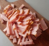 Для начала тщательно смажьте форму растительным маслом и разогрейте духовку до 190 градусов.
В форму ровным слоем выложите макароны. Нарежьте ветчину соломкой и выложите ее на макароны.