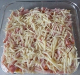 Натрите сыр на крупной терке и посыпьте запеканку, закройте форму с макаронами фольгой. Форма должна быть с высокими бортами, чтобы вода при кипении не выплеснулась.