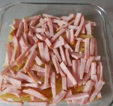 Посыпьте слой ветчины солью и специями по вкусу (не переборщите с солью, ветчина соленая).
Соедините молоко с водой, можно немного посолить смесь. Можно также использовать только молоко, главное не нарушить соотношение макароны-жидкость, ведь они должны свариться.