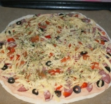 Пиццу сверху засыпьте тертым сыром.