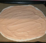 Приготовьте соус, для этого перемешайте сметану, майонез и кетчуп в равных количествах. Раскатайте ¼ часть теста в круг, поместите на противень накрытый бумагой для выпечки, смажьте тесто приготовленным соусом.