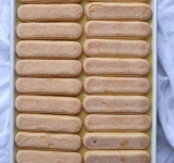 Теперь нанесите слой лимонного курда и выложите третий слой печенья.