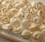 Складываем пельмени на тарелку либо разделочную доску с просыпанной мукой поверхностью и ставим морозилку, либо сразу отвариваем в подсоленной воде.
Подавать на стол лучше с зеленью и сметаной. Приятного аппетита.