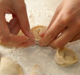 Оба ушка пельменя соединяем.