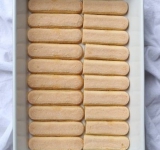 В кастрюлю поместите воду и лимончелло, поставьте на большой огонь и доведите до кипения, варите 5 минут, затем снимите раствор с огня и поставьте остывать. Каждое печенье на секунду окуните в остывшую смесь и выложите первым слоем для десерта.