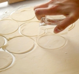 Рабочее место посыпаем мукой, делим тесто на несколько частей и раскатываем в тонкий пласт в 2 мм. Нарезаем из теста кружочки.