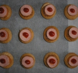 На противень застеленный пергаментом выложите сушки, сверху сосиски, и немного кетчупа.