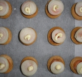 Затем выложите кружочек лука, немного майонеза и посыпьте тертым сыром.