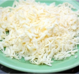 Приготовим начинку, для этого трем на крупную терку сыр и вбиваем туда одно яйцо, перемешиваем.	