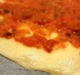 Всю поверхность теста намазываем томатным соусом.	