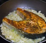 Добавляем к рыбе лук и вино, держим сковороду на огне при постоянном помешивании, пока вино не выпарится (3-4 минуты).