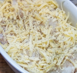 В жаропрочную емкость уложите на дно половину картошки, положите немного сливочного масла, посолите и поперчите, сверху выложите рыбу и половину сыра, посолите и поперчите.	