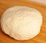 В глубокой посуде замешиваем все сыпучие ингредиенты для теста, делаем углубление посередине горки, заливаем туда теплую воду и добавляем 1 яйцо. Замешиваем 5-6 минут, затем накрываем тесто пищевой пленкой и даем постоять 10-20 минут.