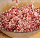 К фаршу добавляем масло и мелко натертый картофель все хорошо перемешиваем.