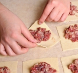 Складываем тесто в длинную широкую полоску, нарезаем на квадраты. В каждый квадратик в центр укладываем начинку.