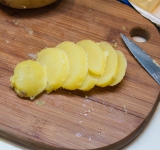 Картофель вытащите из сковороды, очистите от кожуры и порежьте на дольки (толщиной около 1 см).