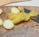 Первым делом отварите картофель в мундире до готовности. Затем очистите от кожуры и нарежьте на ломтики толщиной около 1 см.	