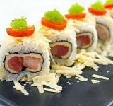 Разрезаем рулет на кусочки и оформляем блюдо помидорами и тобико. Подаем на стол.