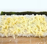 Натираем сыр «Пармезан» и равномерно распределяем его по заготовке ролла.