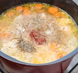 Добавьте рыбу в суп вместе с томатной пастой, соль, перцем, сушеной зеленью и лавровым листом. Готовьте еще 30 минут на слабом огне.