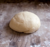 . Перемешиваем и постепенно добавляем муку, хорошо вымешиваем и разминаем тесто на рабочем месте, периодически добавляя муку. Перекладываем тесто в смазанную сливочным маслом миску, закрываем полотенцем и ставим на полтора часа в теплое место, чтобы тесто поднялось.