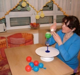 Надуваем шарики, но не сильно, перевязываем длинной ниткой (так, чтобы в дальнейшем было удобно закрепить шарики для сушки). С помощью кондитерского мешочка наносим на надутый шарик узоры.	