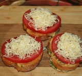 На готовые гренки выкладываем тонкий кружочек помидора, слегка солим и перчим, посыпаем тертым сыром.